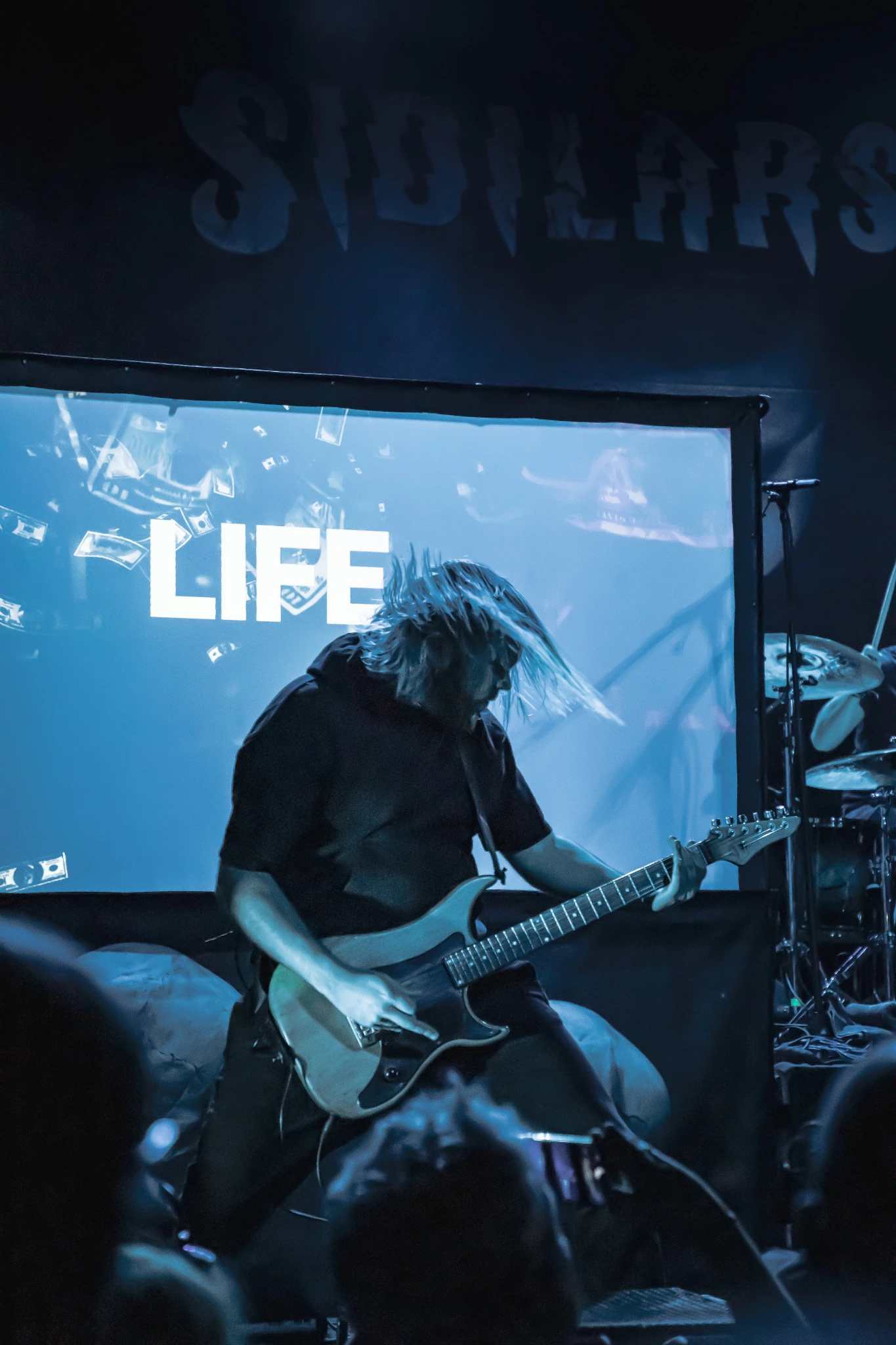 Photographie d'un concert sous les lumières de scène