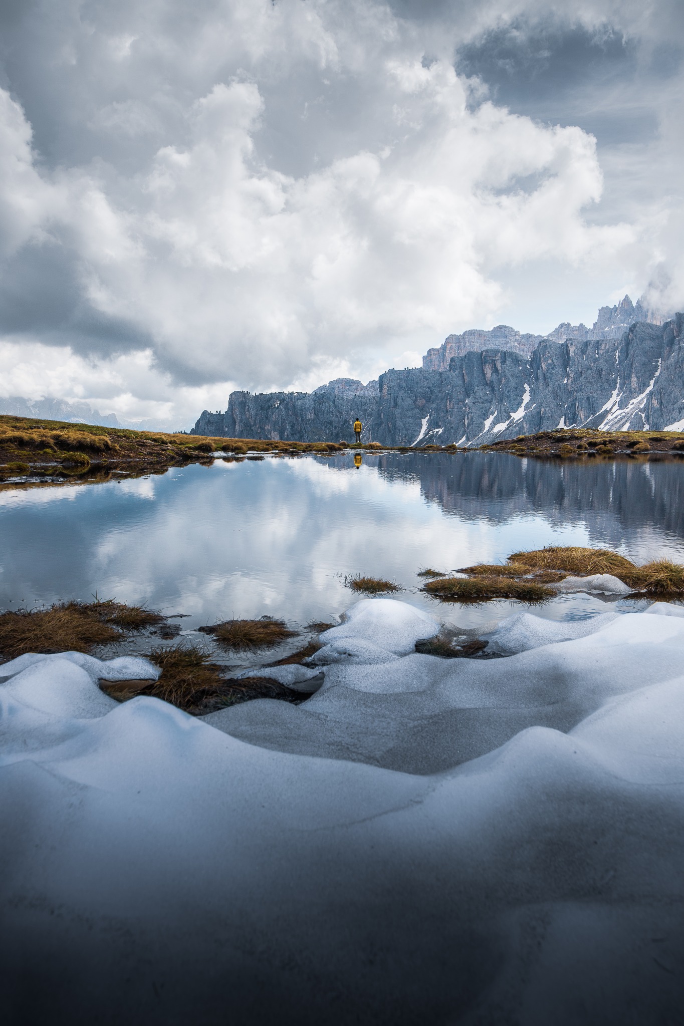 Montagnes et nuages se reflétant dans un lac bordé de rochers
