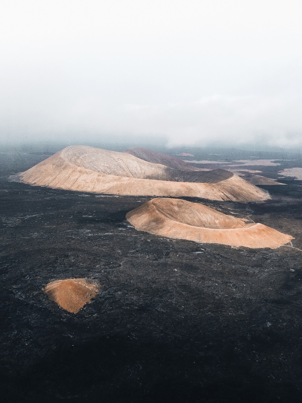 Cratères ocre au milieu des champs de lave noire de Lanzarote