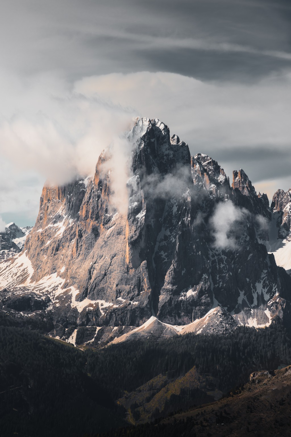 Sommet rocheux éclairé par le soleil et enveloppé de nuages