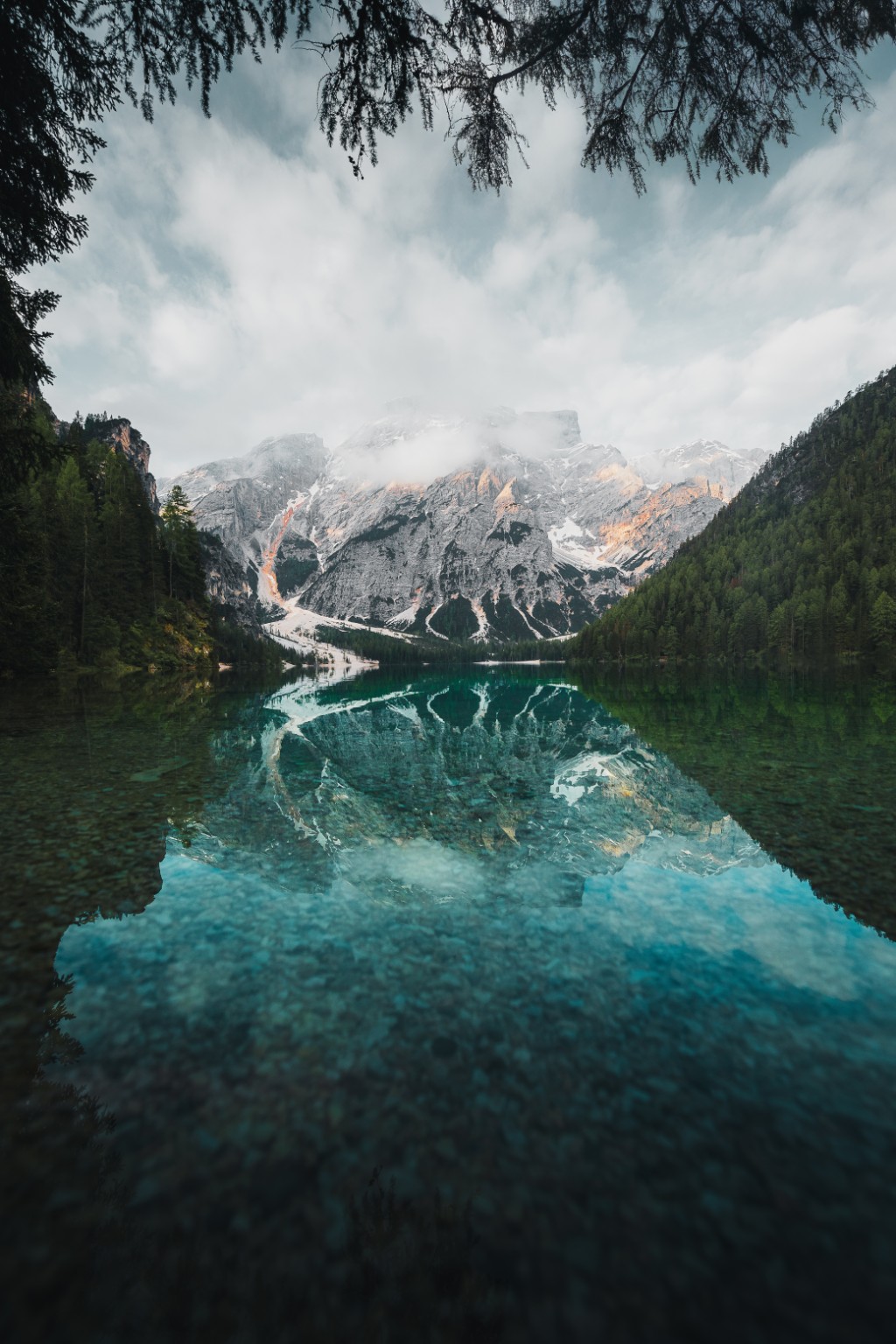 Montagnes et forêt se reflétant dans les eaux turquoise d’un lac