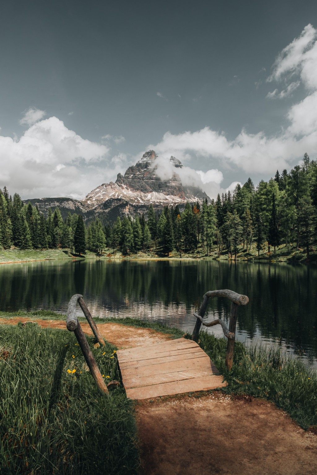 Petit ponton au bord d’un lac de montagne entouré de conifères