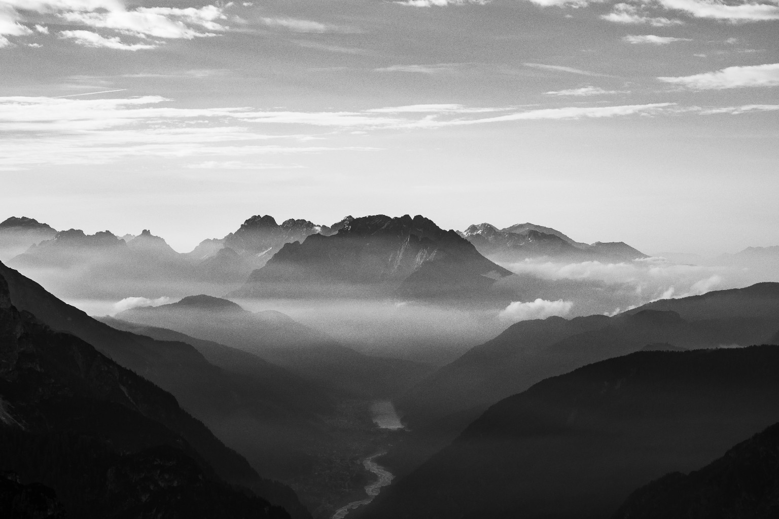 Montagnes en noir et blanc émergeant de strates de brume